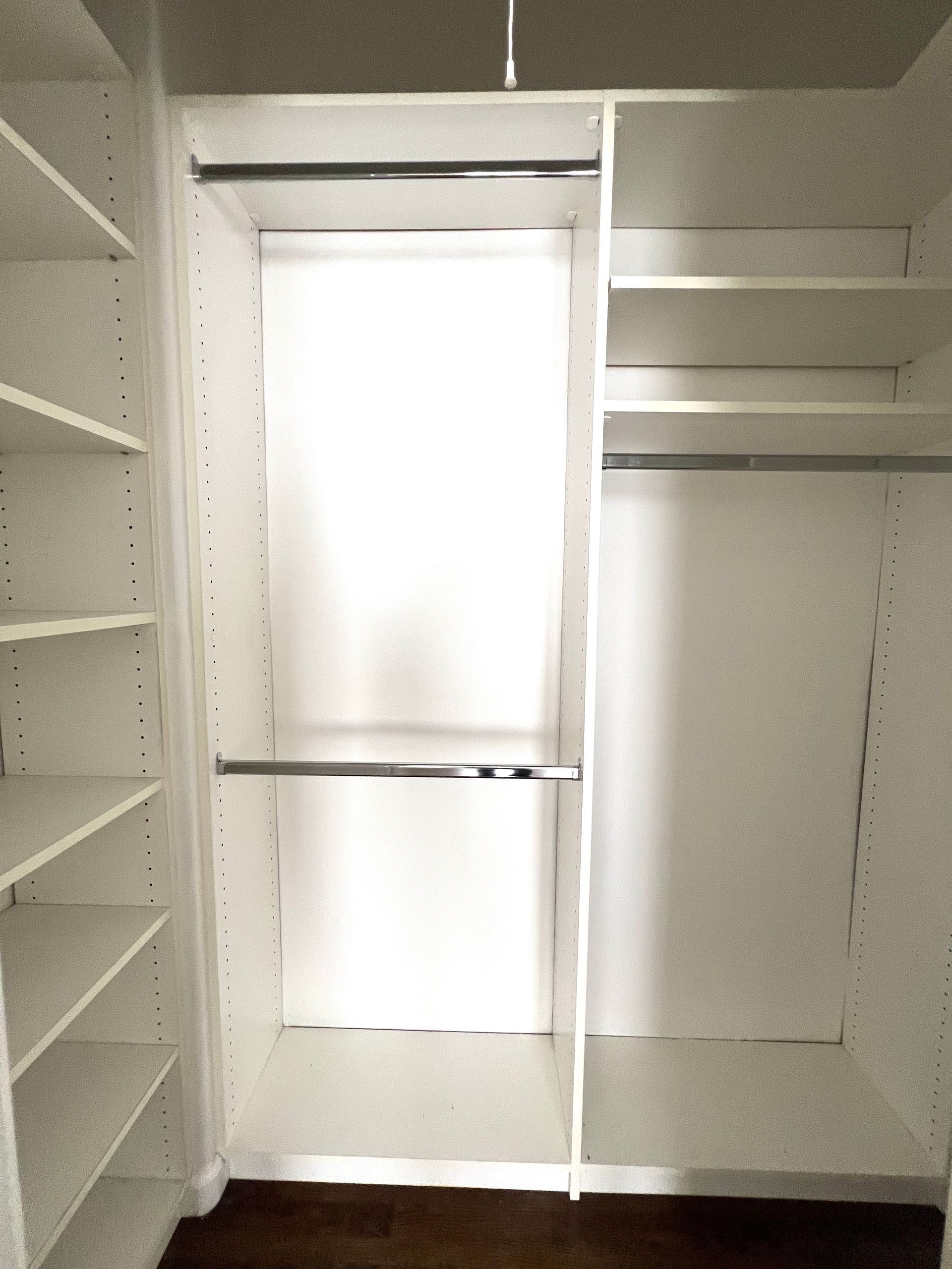 A walk in closet with shelves and a window