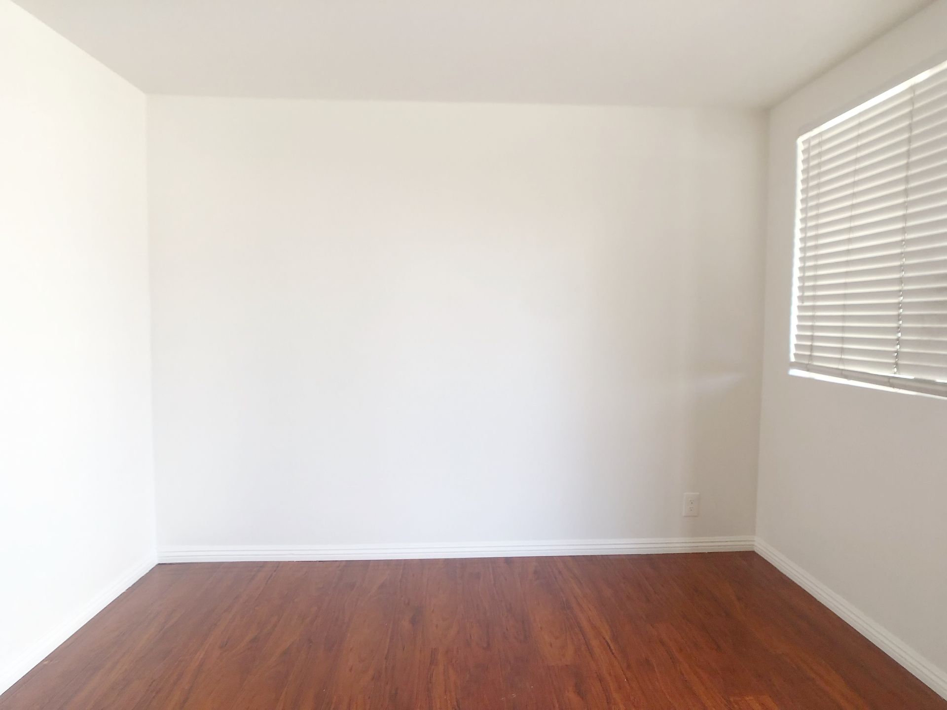 An empty room with a window and blinds