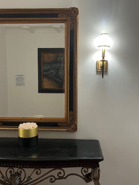 A mirror and a table with a vase of flowers on it