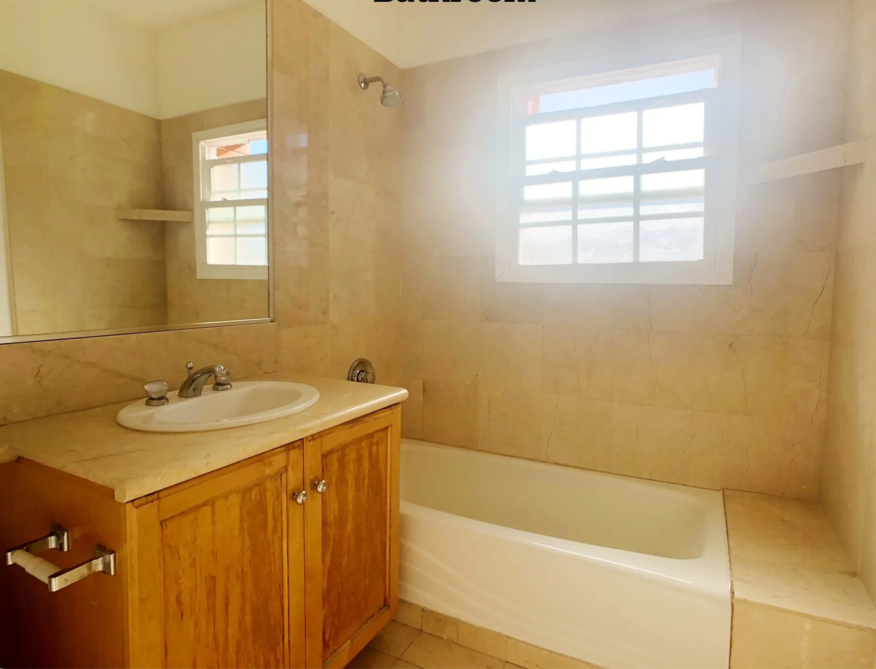 A bathroom with a sink , tub , mirror and window