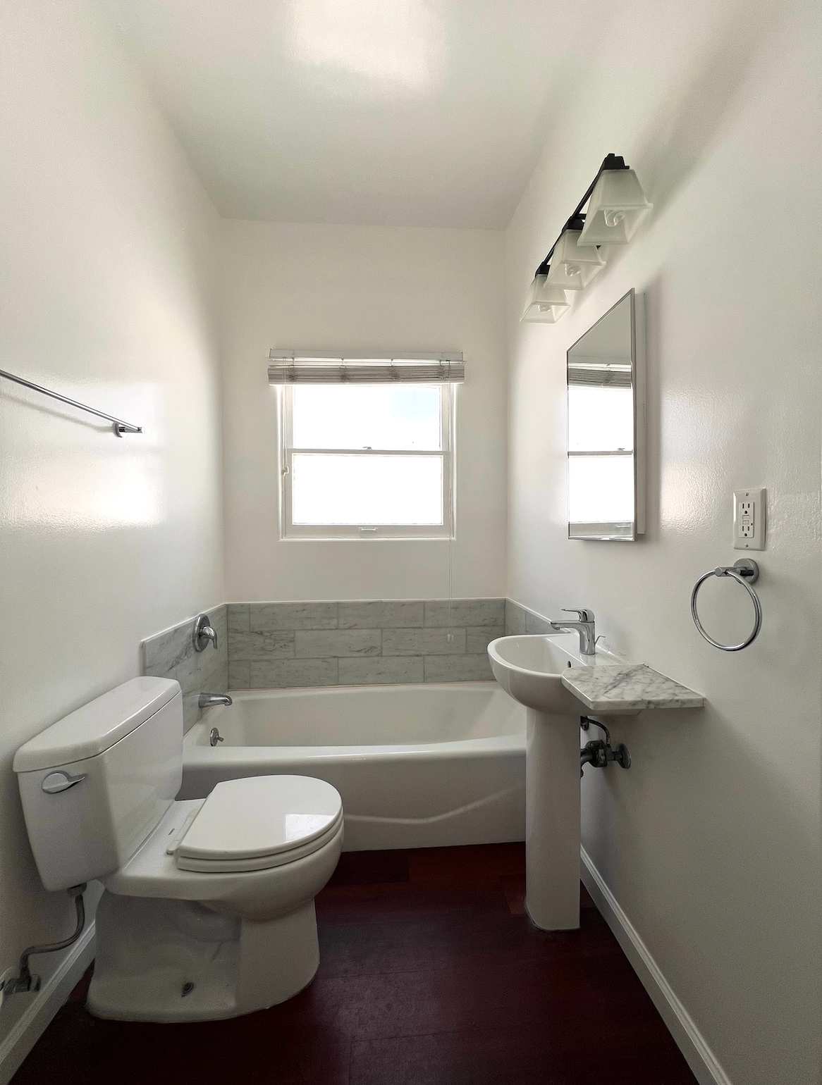 A bathroom with a toilet a sink and a bathtub