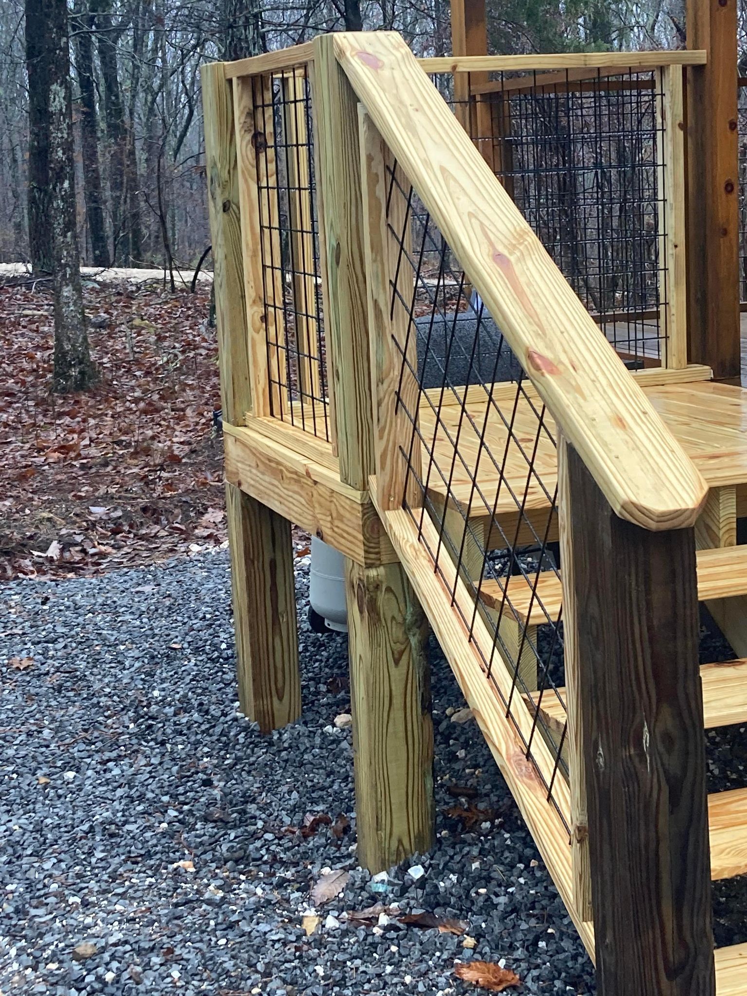 A wooden deck with stairs and a rope railing.