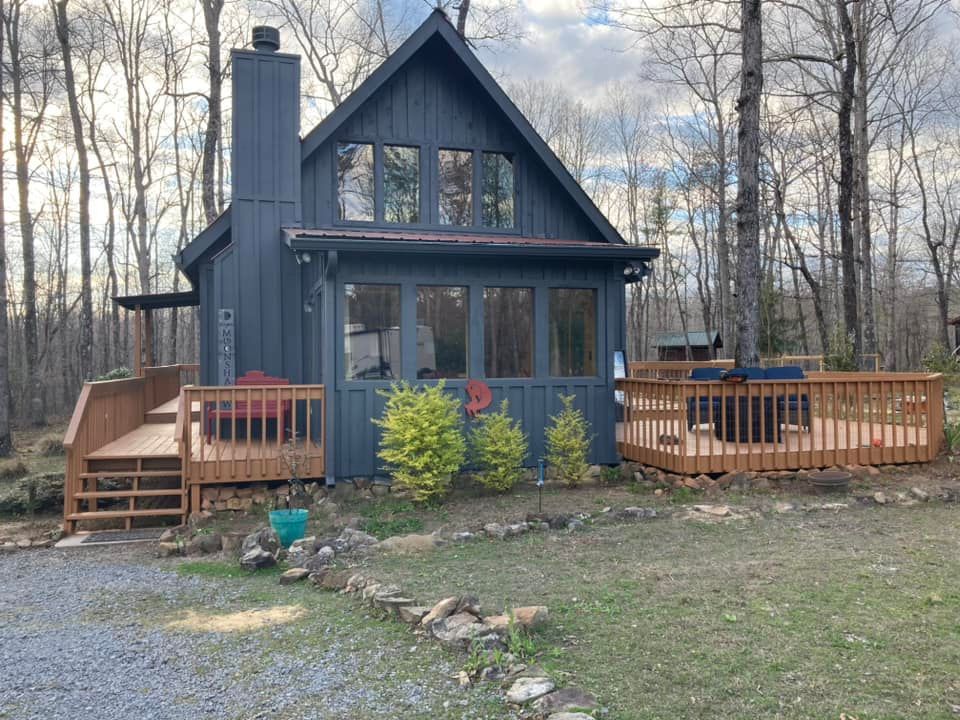 A small house with a large deck in the woods