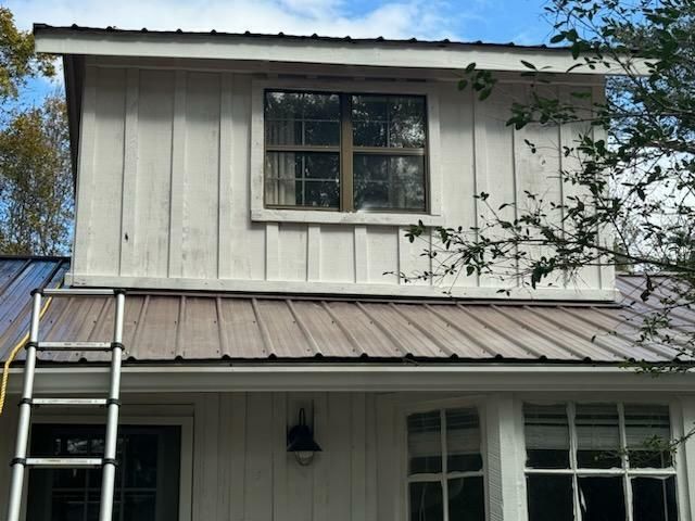 A white house with a metal roof and a window