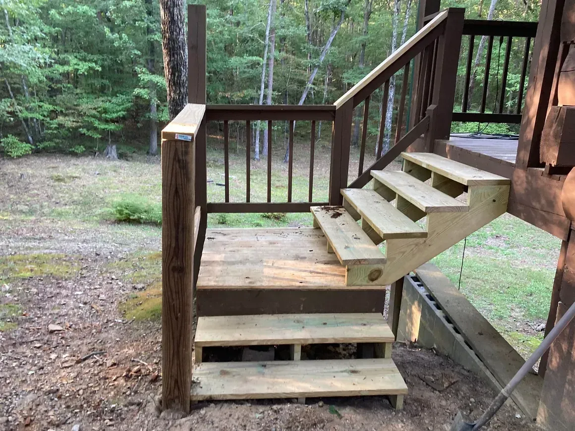 A wooden deck with stairs leading up to it