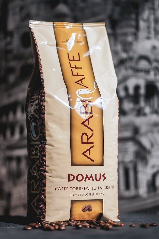 hot coffee served with a lot of coffee beans around it