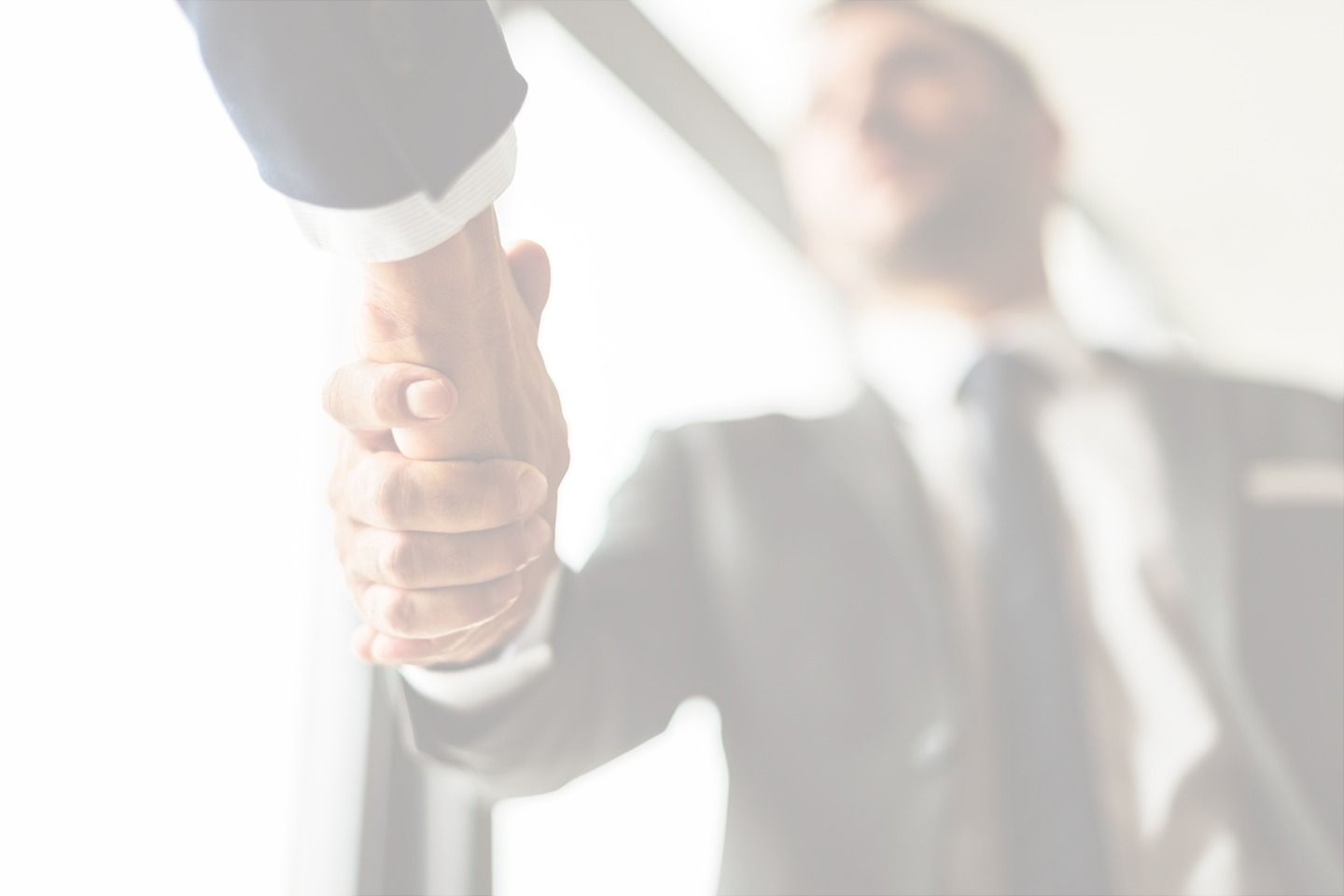 Two men in suits shaking hands; business deal.