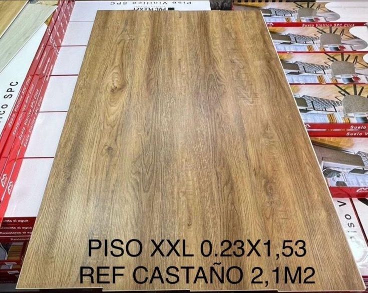 Muestra de baldosa de imitación madera; color marrón claro con veta de madera. Texto en la parte inferior: 