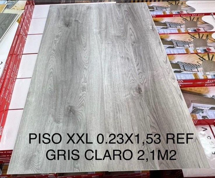 Muestra de baldosa de suelo imitación madera gris. Texto: PISO XXL 0.23X1,53 REF GRIS CLARO 2,1M2.