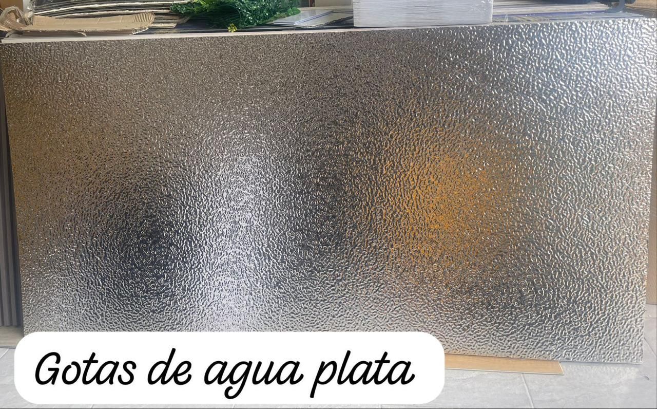 Panel texturizado de color plateado, que recuerda a gotas de agua. Texto en español 