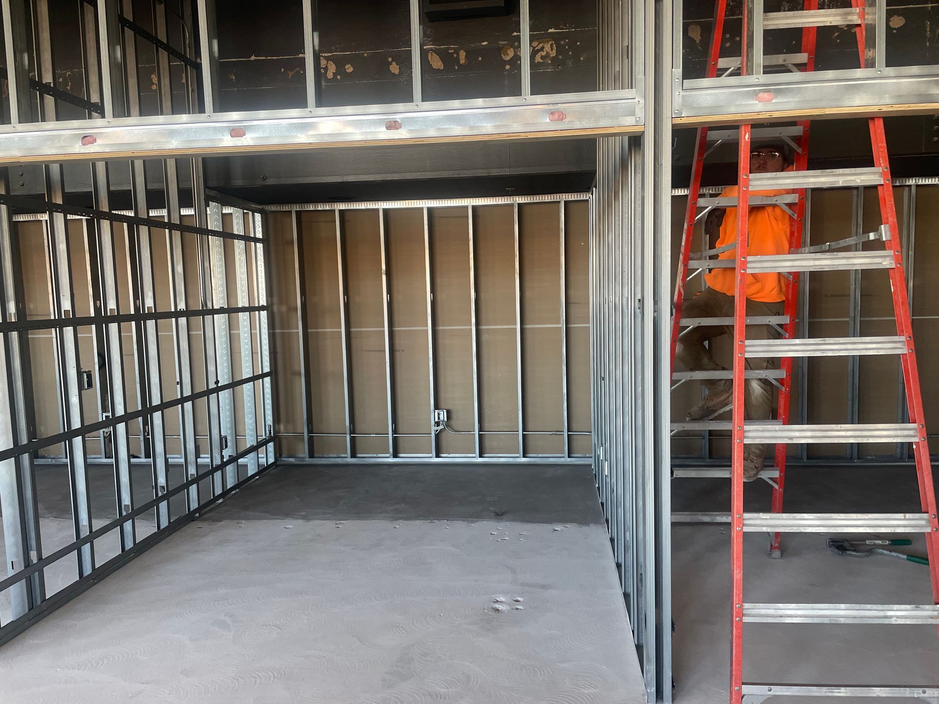 A woman is working on a electrical panel in a room.
