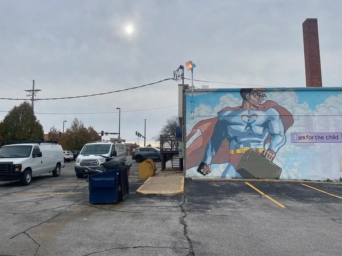 A mural is being painted on the side of a building.
