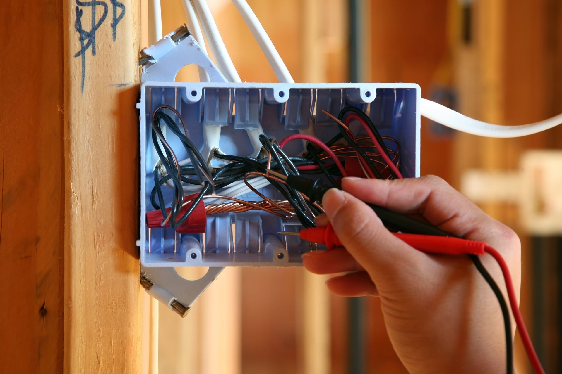 Close-up of electrical switch being tested by an electrician with a tool.