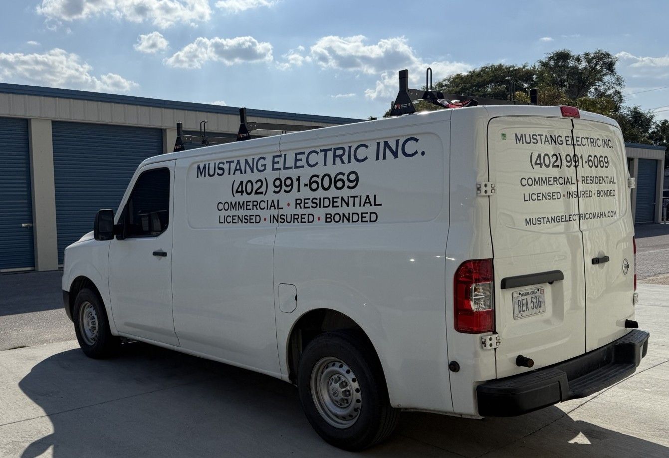 A man wearing a hard hat and safety glasses is working on a machine.