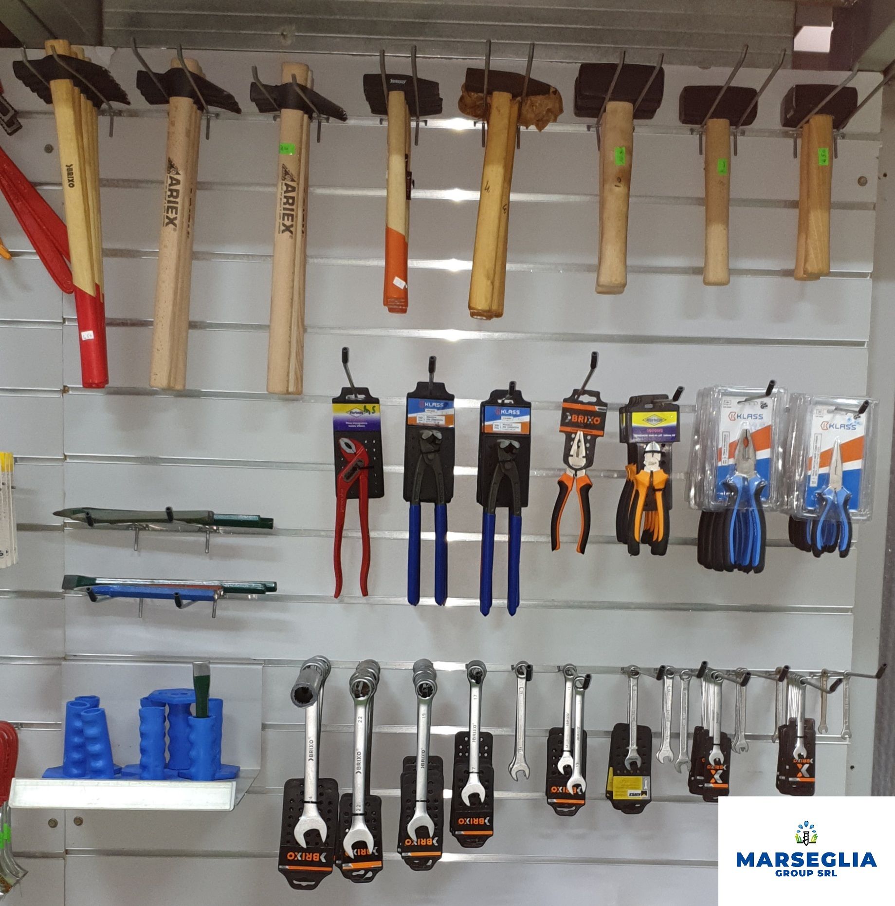 Attrezzi esposti su una parete in un negozio: martelli, pinze e chiavi inglesi.