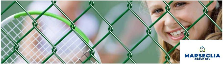Una persona sorridente sbircia attraverso una recinzione verde, accanto a una racchetta da tennis. Un logo è visibile nell'angolo in basso a destra.