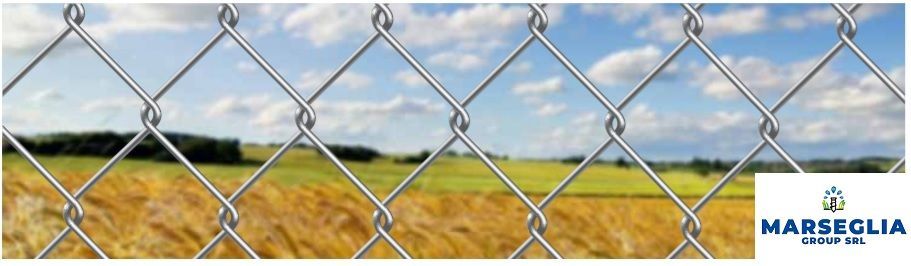 Recinzione in rete metallica con sfondo di paesaggio rurale e logo Marceglia Group SpA.