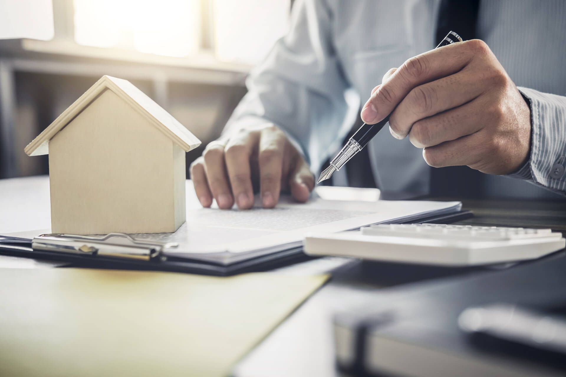 Signing Document Beside A Model House