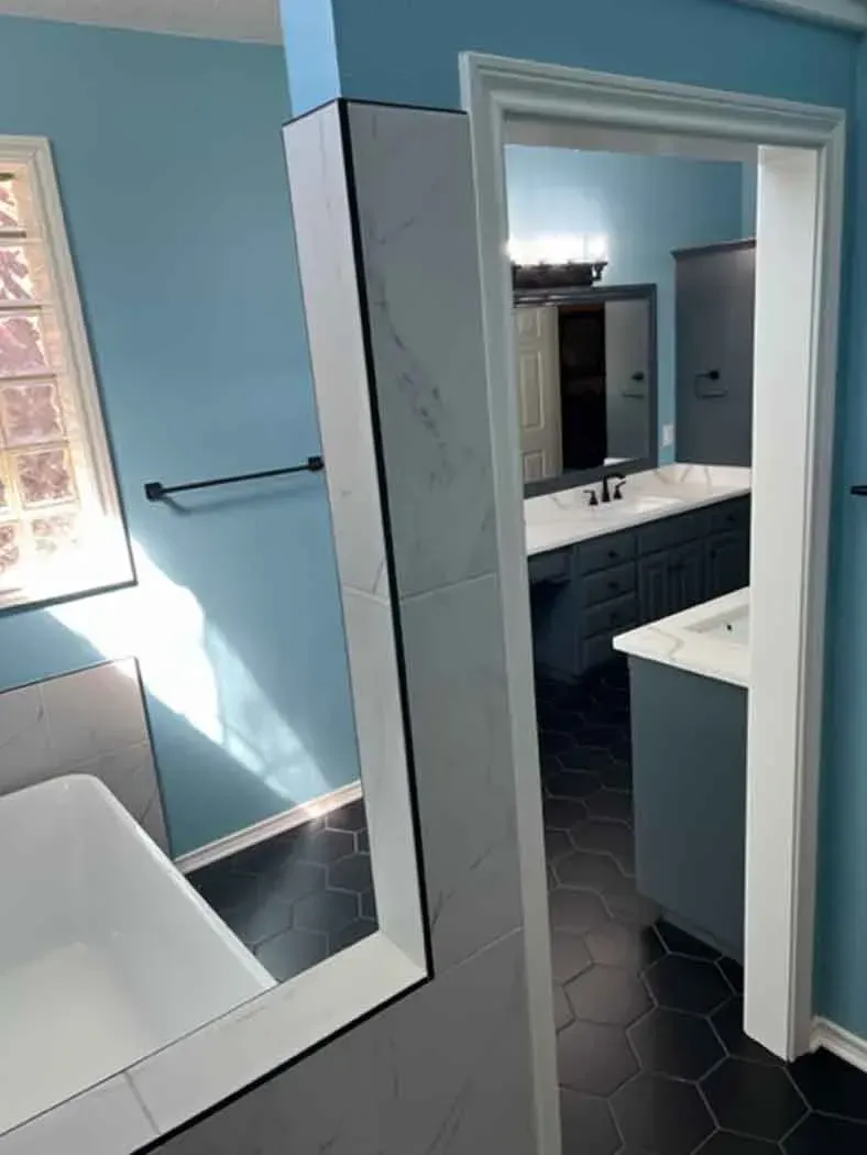 Bathroom with blue walls, white trim, and dark hexagon floor tiles.