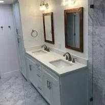 Bathroom with double sink vanity, two mirrors, and marble tile floor.