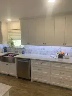 White kitchen with stainless steel appliances and cabinets.