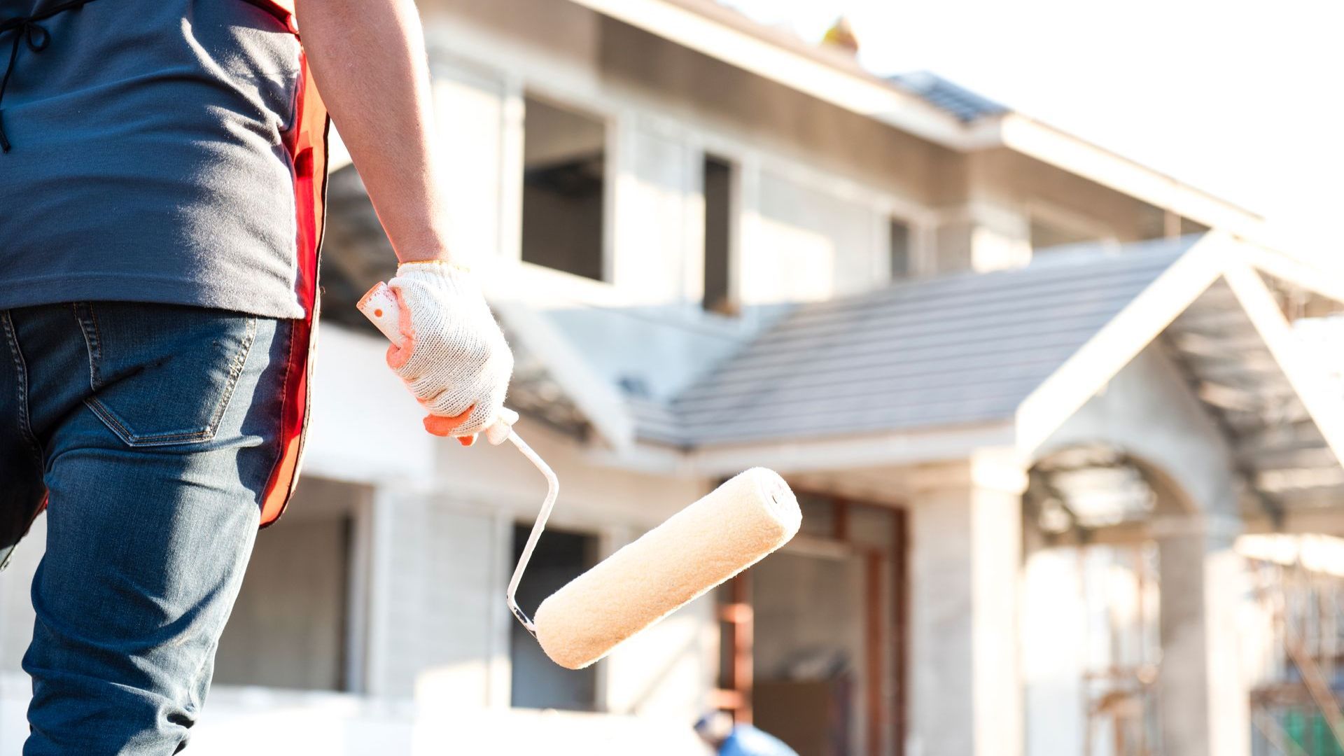 A carpenter holding a paint roller