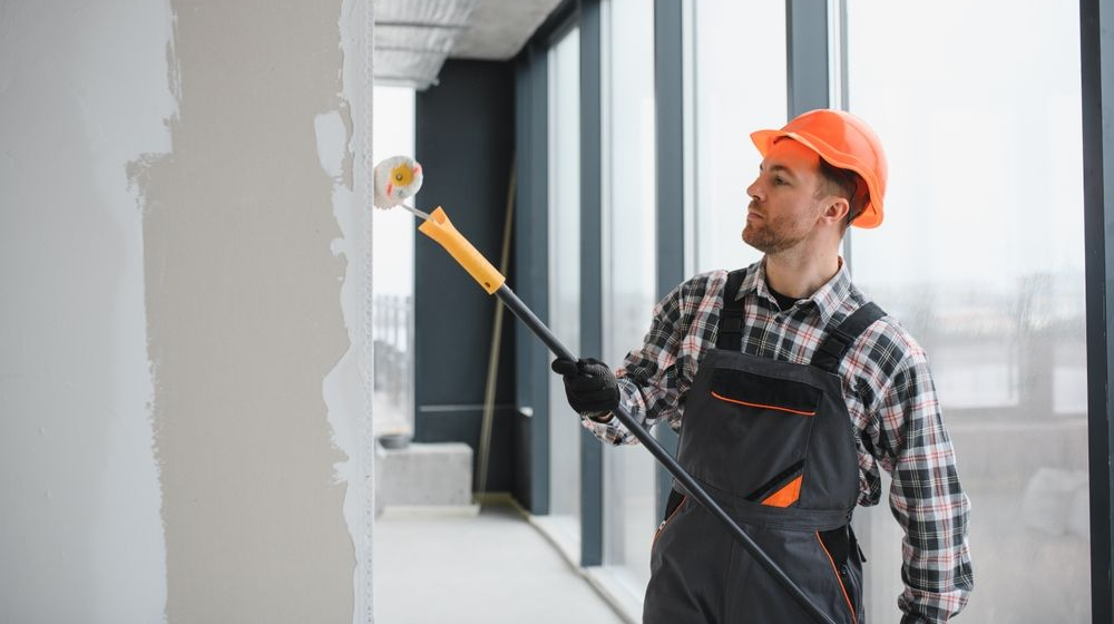 A carpenter holding a paint roller