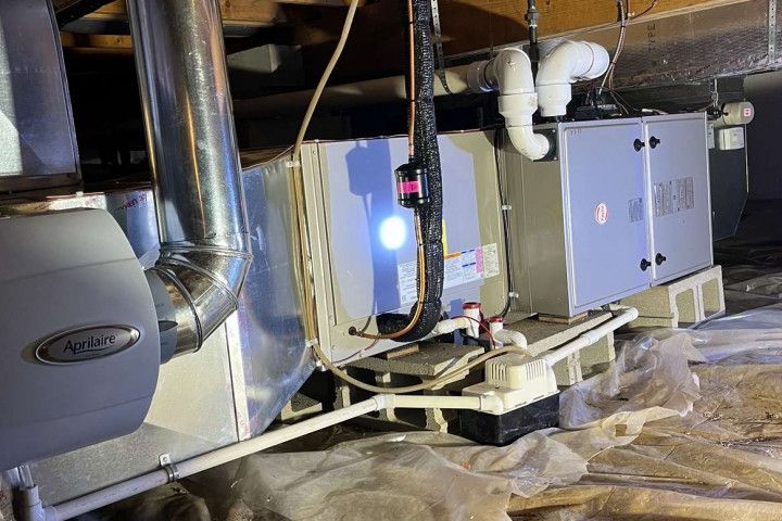 A couple of furnaces are sitting in a basement.