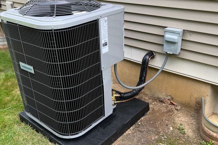 A large air conditioner is sitting outside of a house.