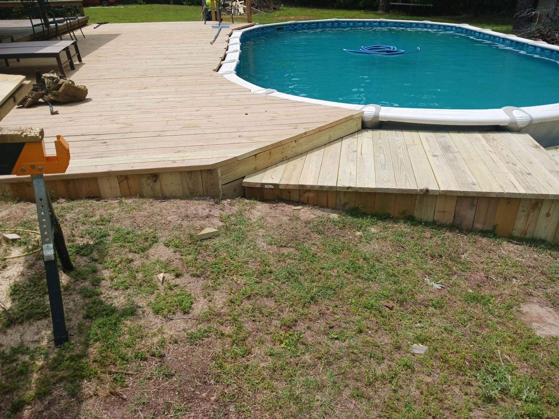 A large swimming pool is surrounded by a wooden deck.
