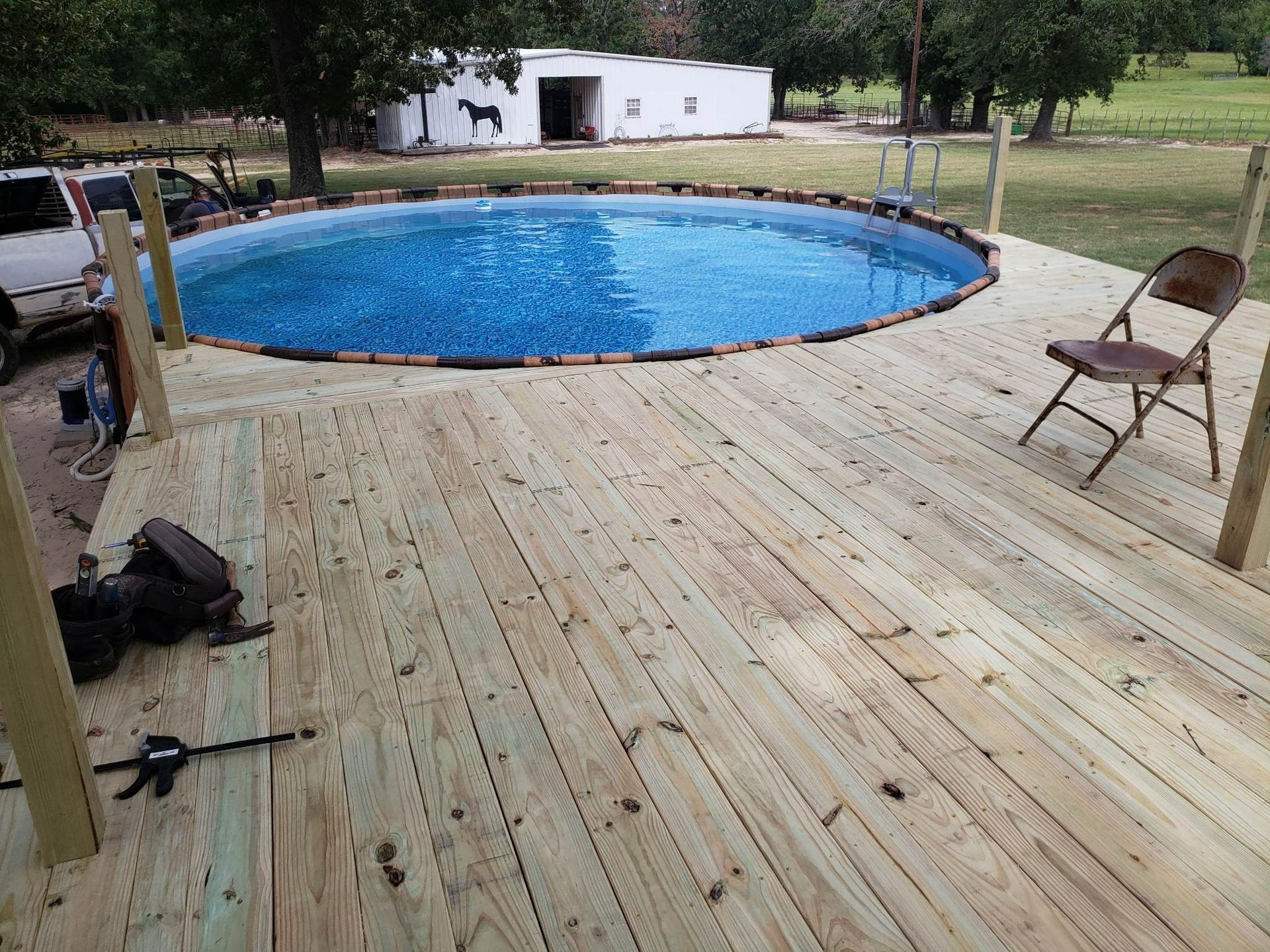 A wooden deck with a swimming pool in the middle