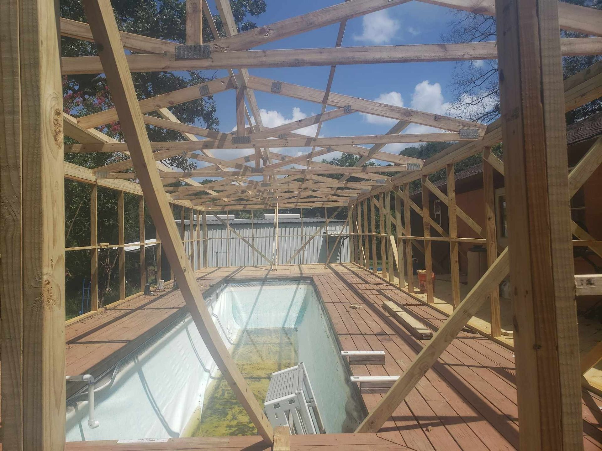 A wooden structure is being built over a swimming pool.