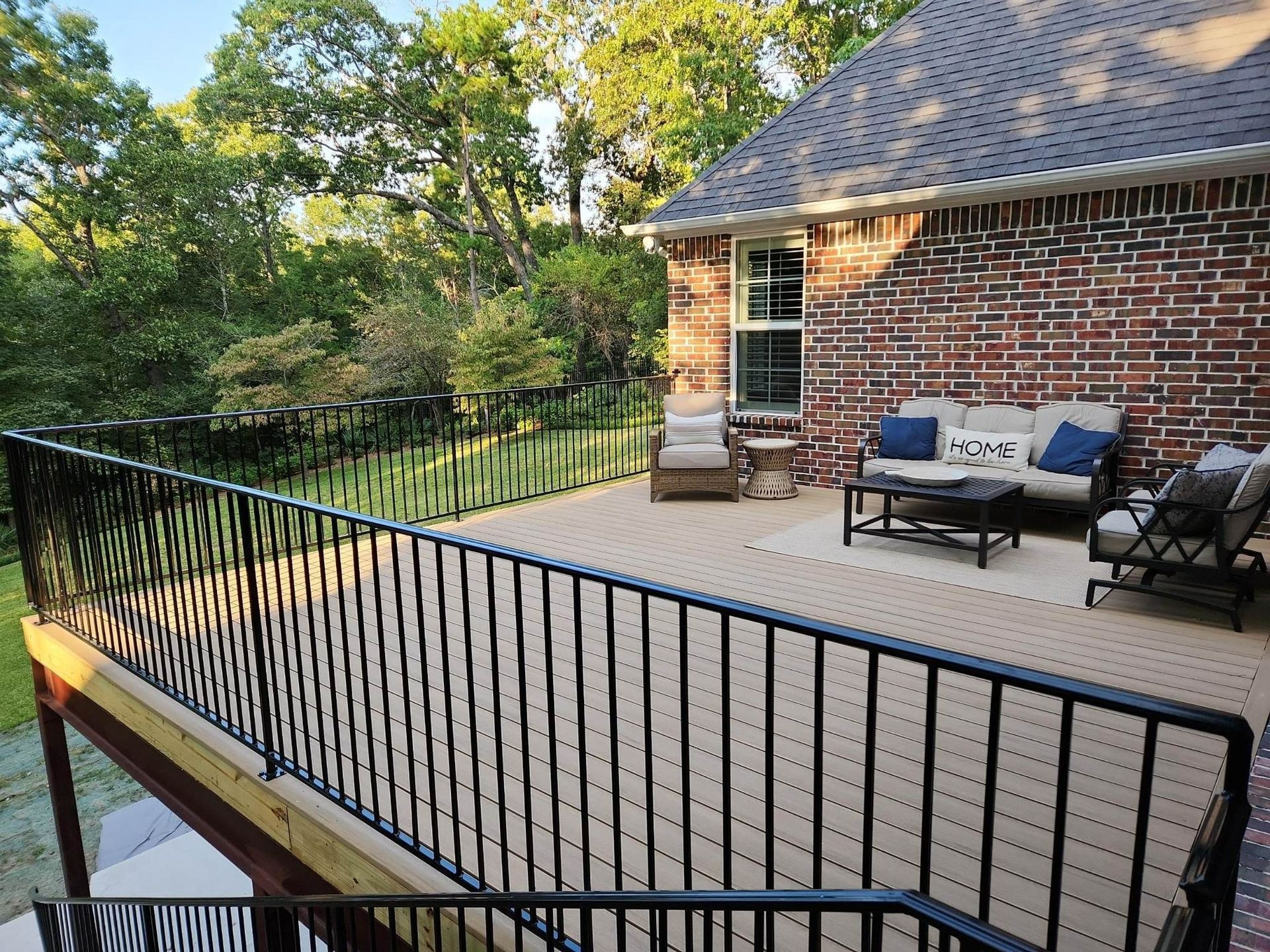 A patio with a couch , chairs , and a table on it.