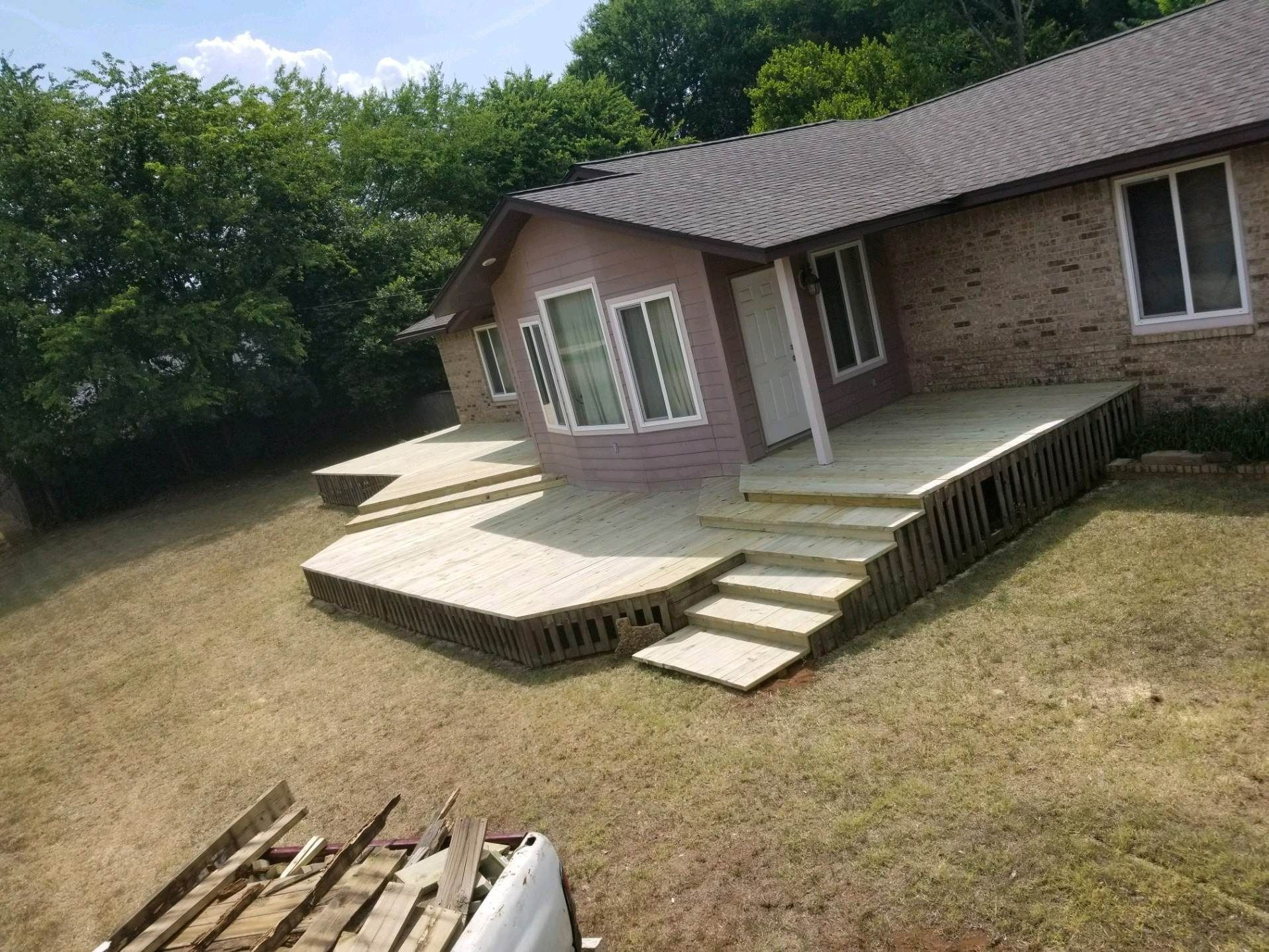 A house with a large deck and stairs in front of it.