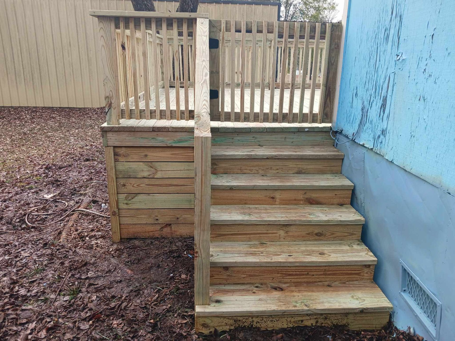 A wooden deck with stairs leading up to it.