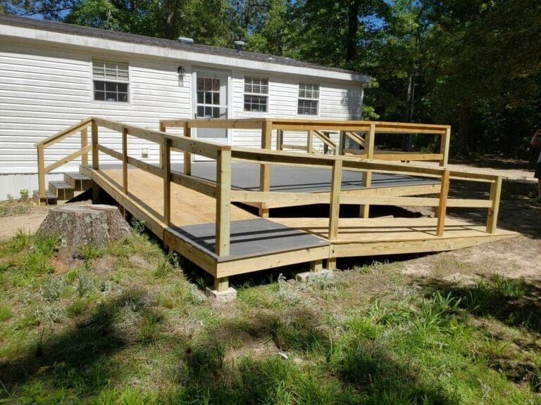 A wooden ramp is being built in front of a mobile home.