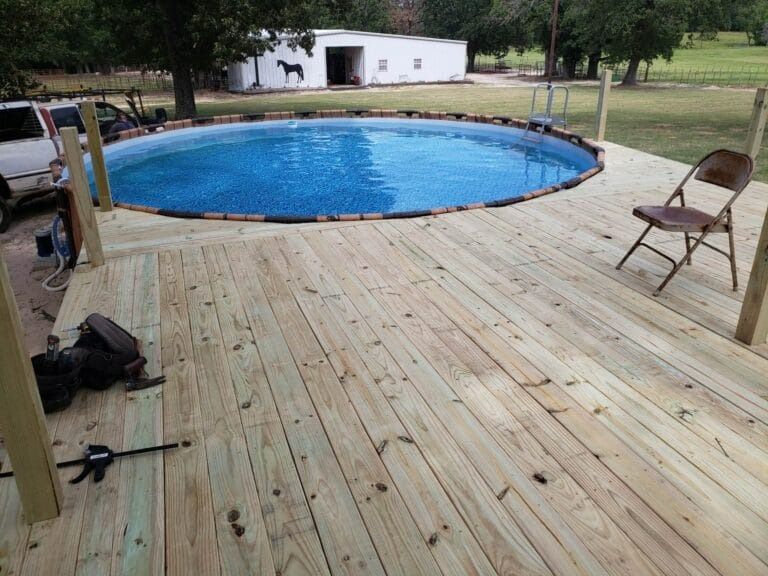 A wooden deck with a swimming pool in the middle