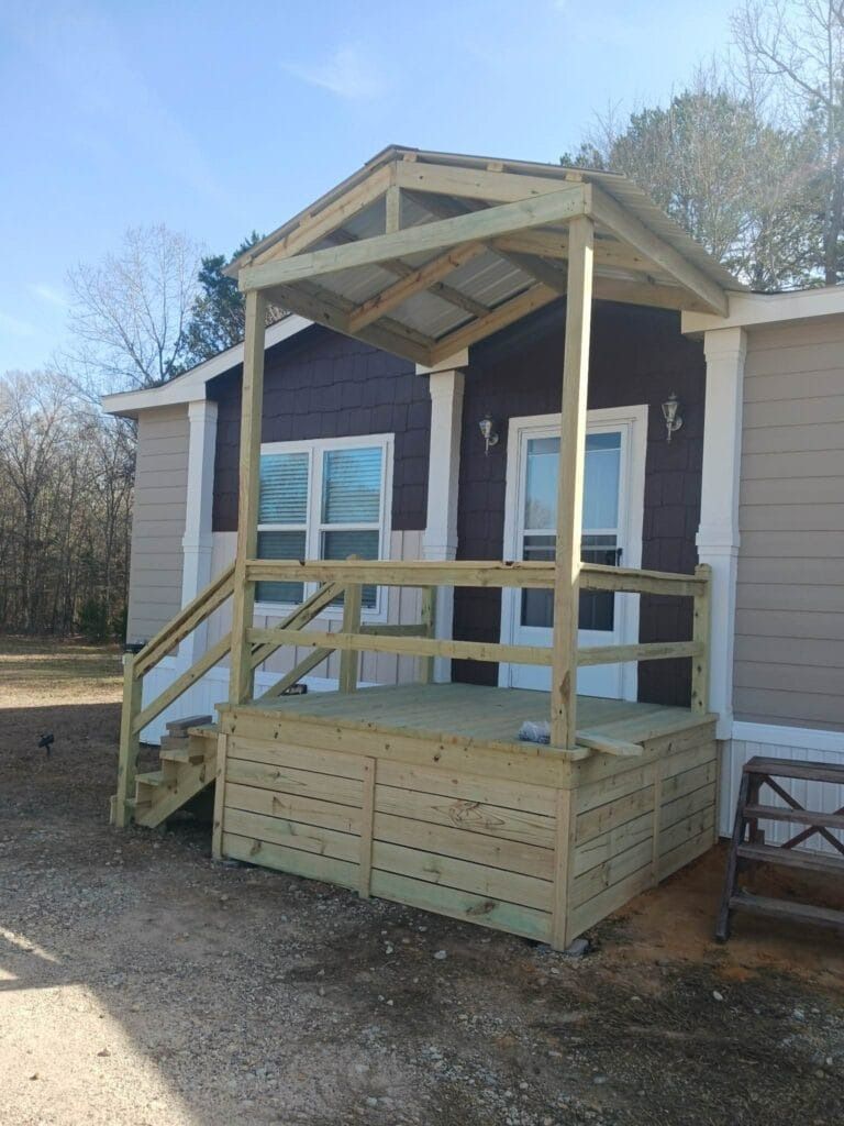 A small house with a wooden porch and stairs.
