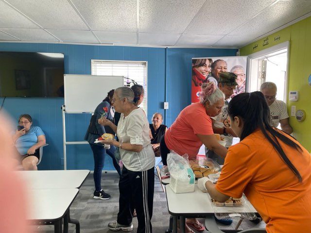A group of people standing around tables in a room