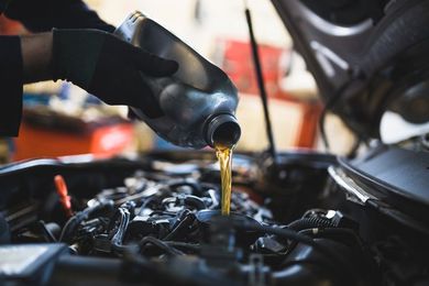 Oil Change Center Aurora, IL — Man Refueling Auto Oil in Aurora, IL