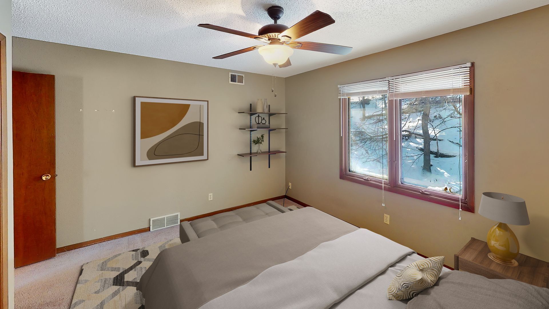 A bedroom with a large bed and a ceiling fan.