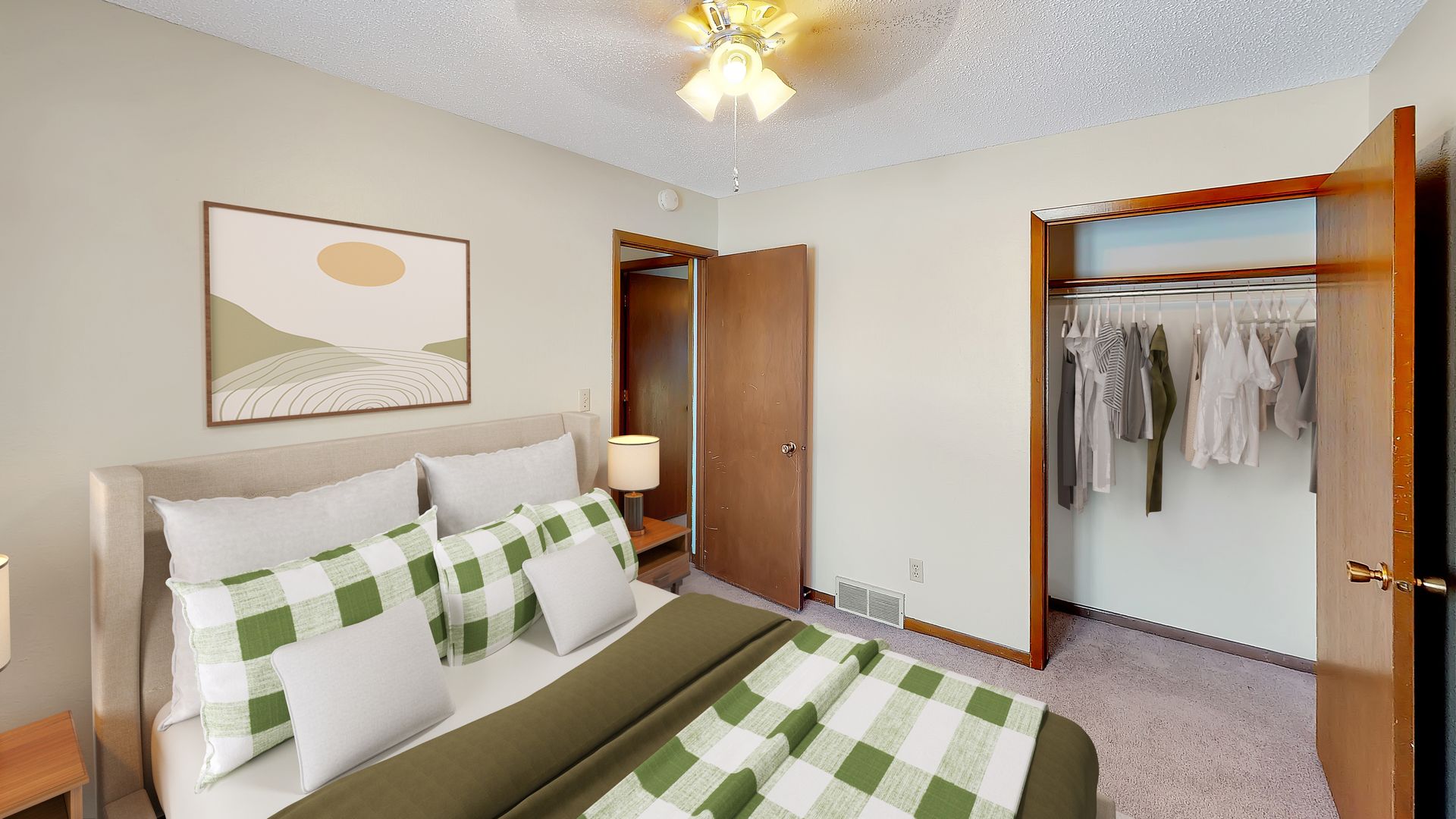 A bedroom with a large bed and a ceiling fan.