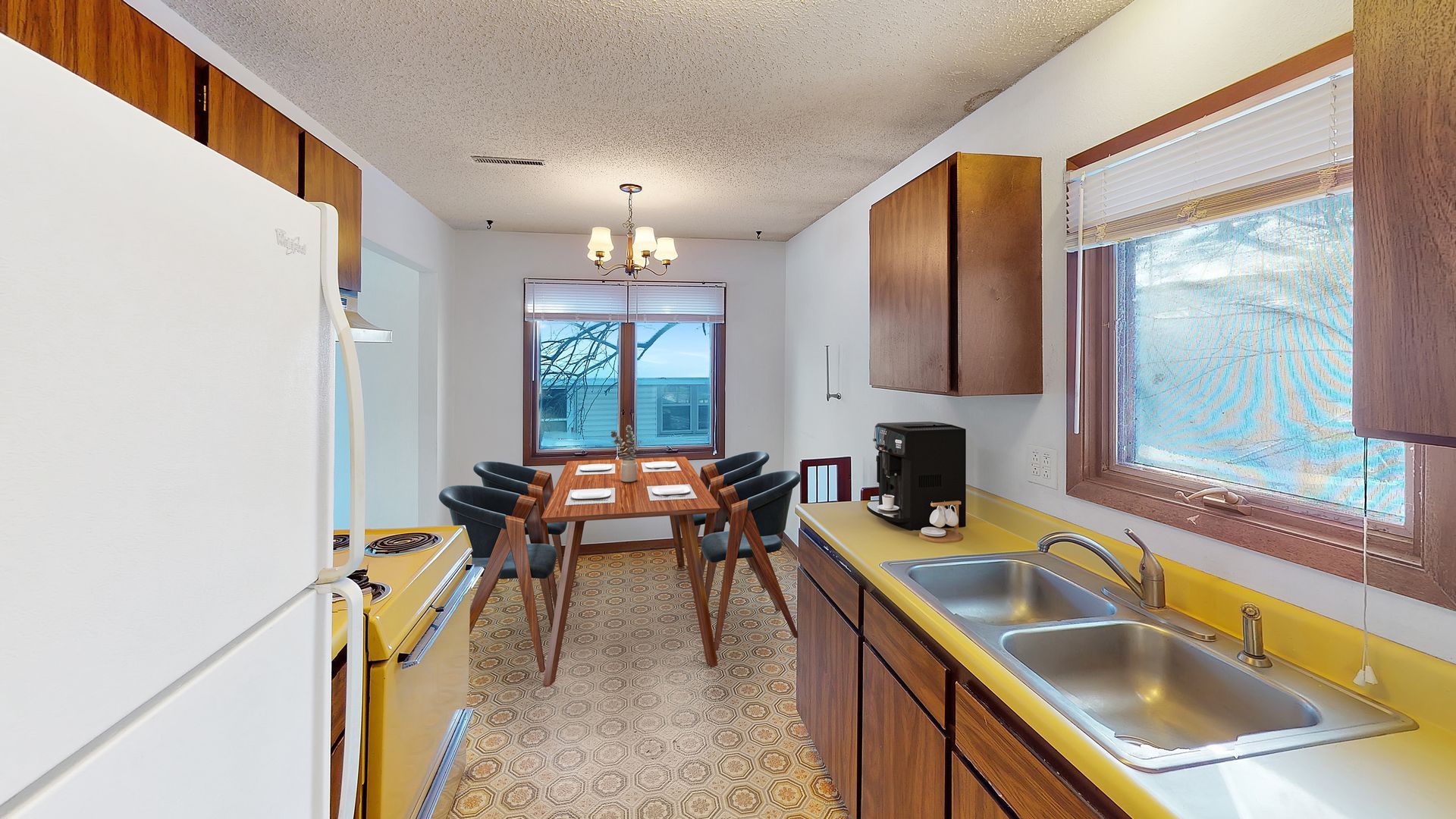 A large brown house with a garage and trees in the background.