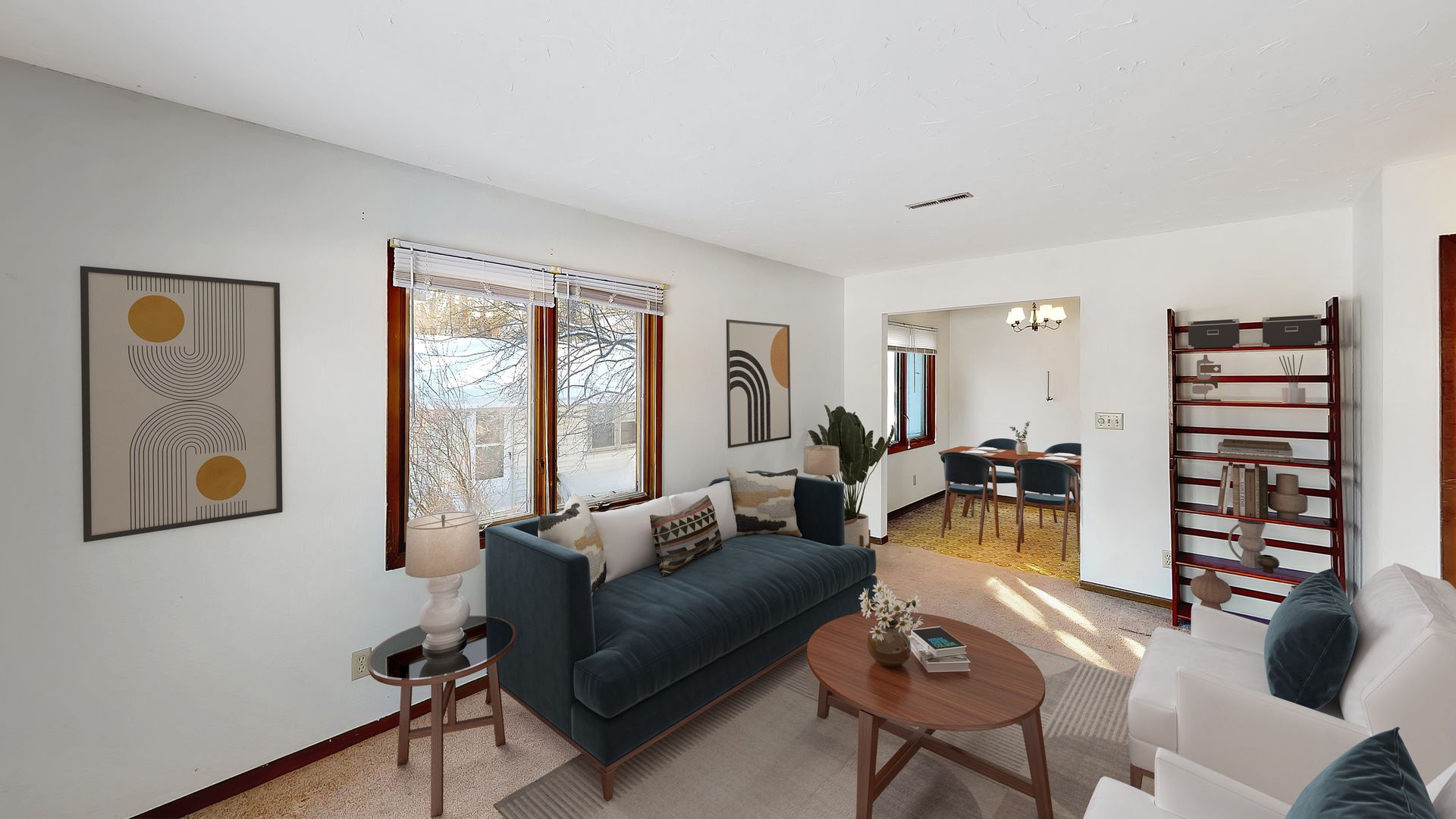 A living room with a blue couch , white chairs , and a coffee table.