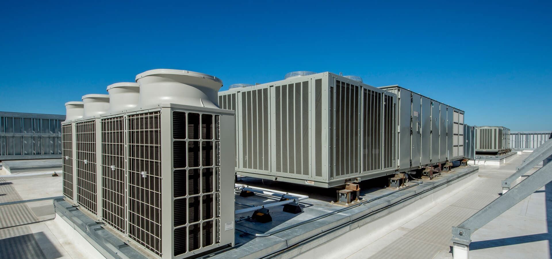 Hay muchos aparatos de aire acondicionado en el tejado de un edificio.