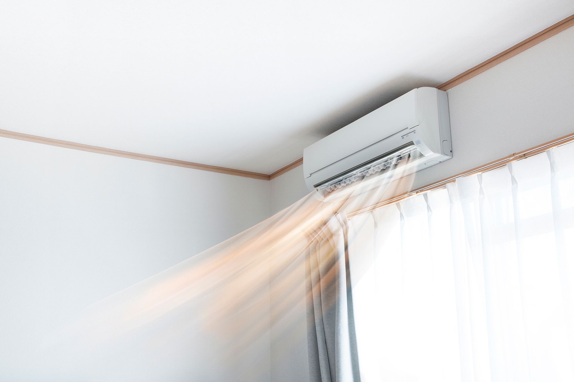 Un acondicionador de aire de habitación está soplando aire desde una ventana.