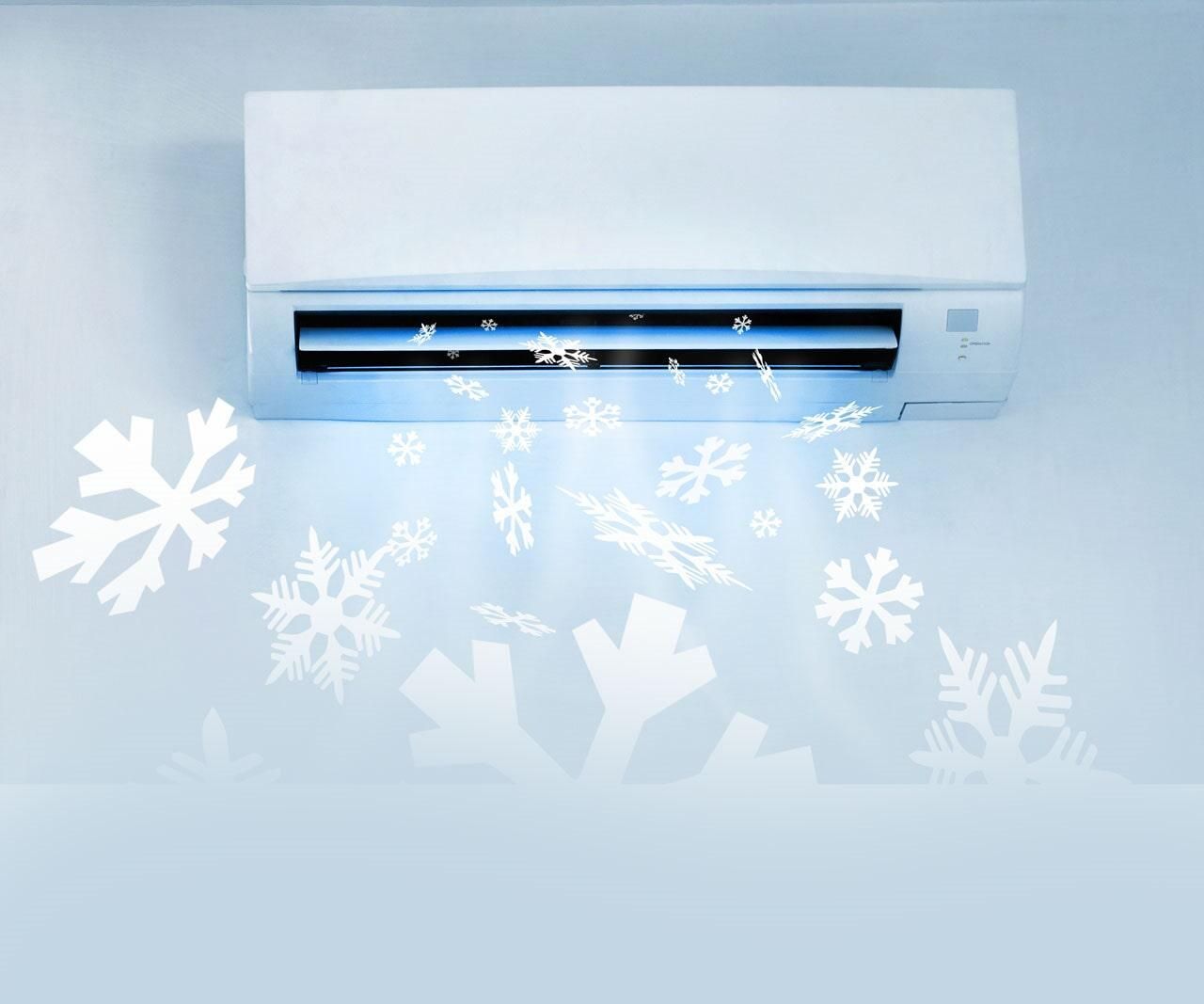 Un acondicionador de aire blanco está colgado en una pared con copos de nieve saliendo de él.