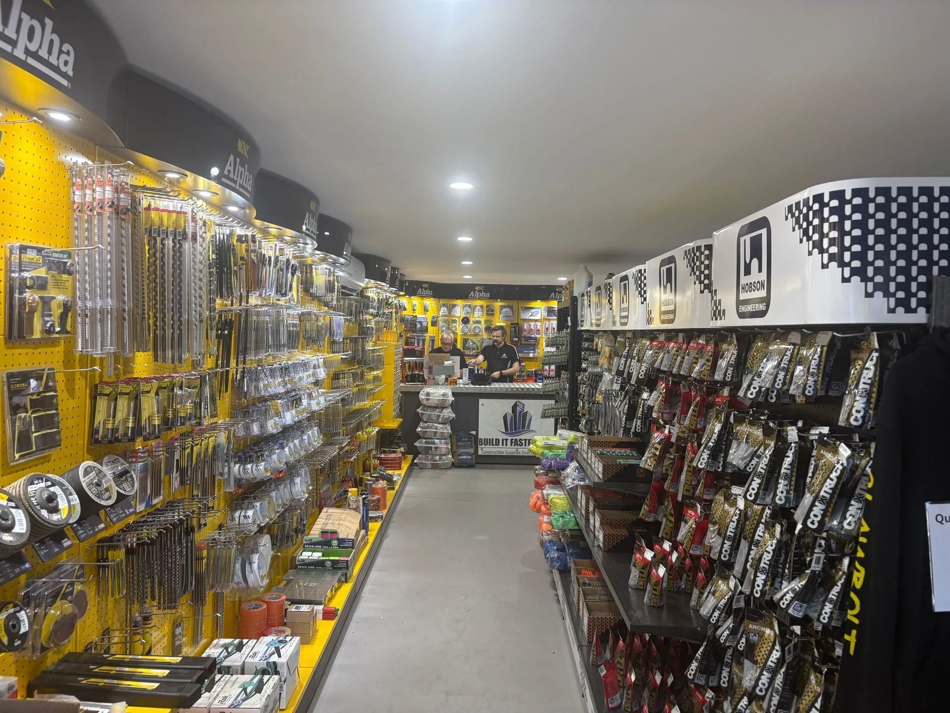Orange forklift in front of a building with a blue sign.