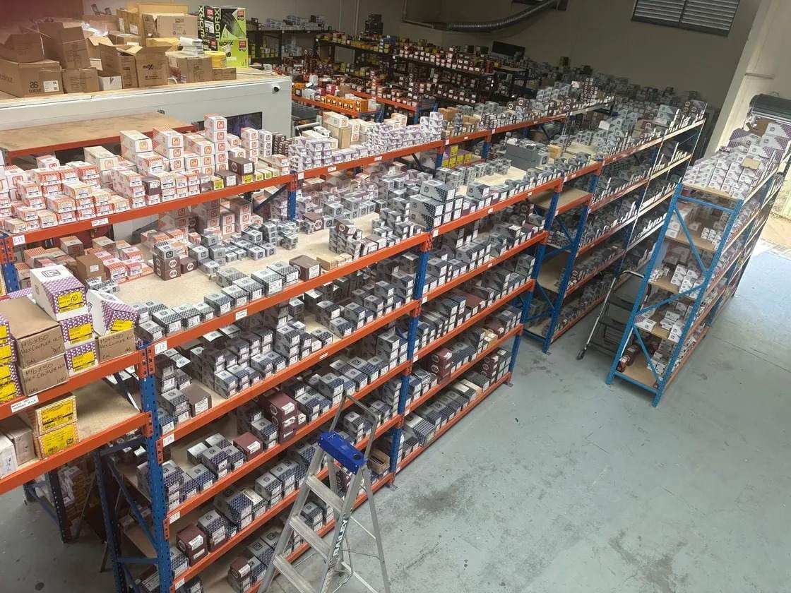 Warehouse with shelves packed with various packaged auto parts.
