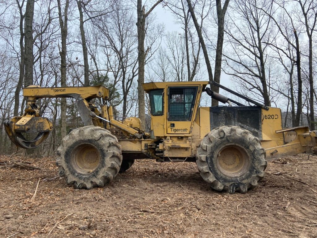 Yellow forestry machine in a wooded area.